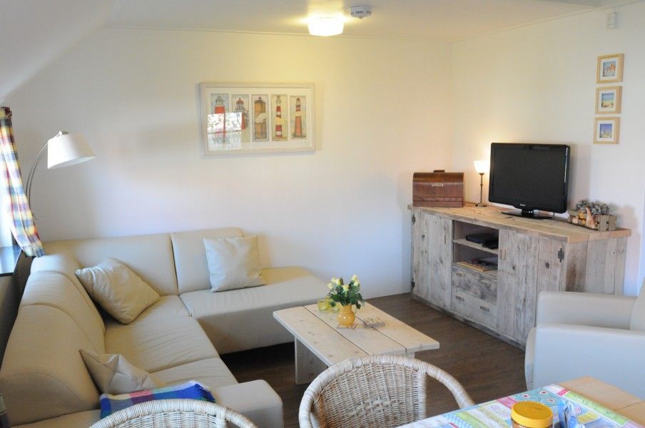 Stylish sitting area in Anja Hoeve Texel, Den Hoorn, vacation home with bright furnishings and comfortable sofas.