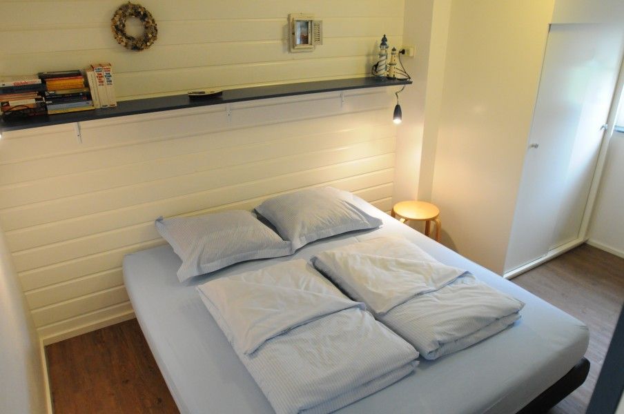 Cozy bedroom in Anja Hoeve Texel, Den Hoorn, vacation home with comfortable double bed and attractive decoration.