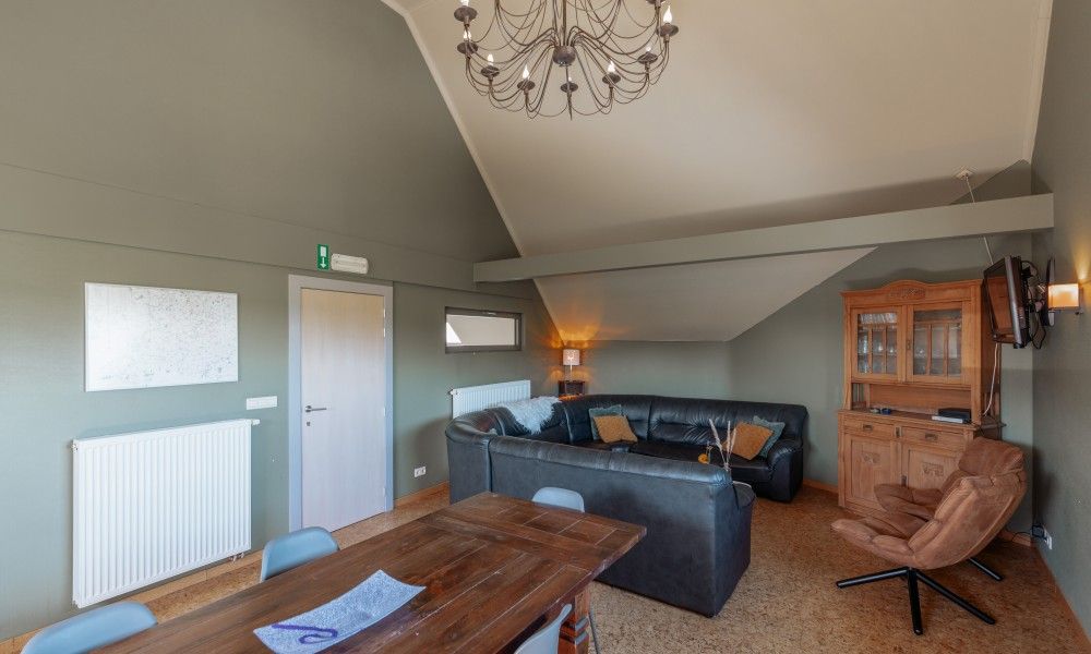 Gemuetliches Wohnzimmer im Ferienhaus De Bronne, Flaemische Ardennen, mit komfortabler Sitzecke.