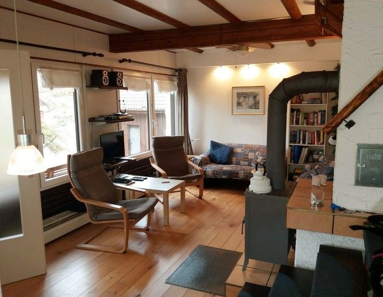 Gezellige woonkamer van Ekkie's Ecke vakantiehuis in Frankenau, Hessen, Duitsland, met houten interieur en comfortabele zithoek.