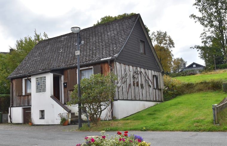 Huisje in Langewiese, een charmant vakantiehuis in Sauerland, Duitsland, omgeven door groene natuur en een rustieke uitstraling.