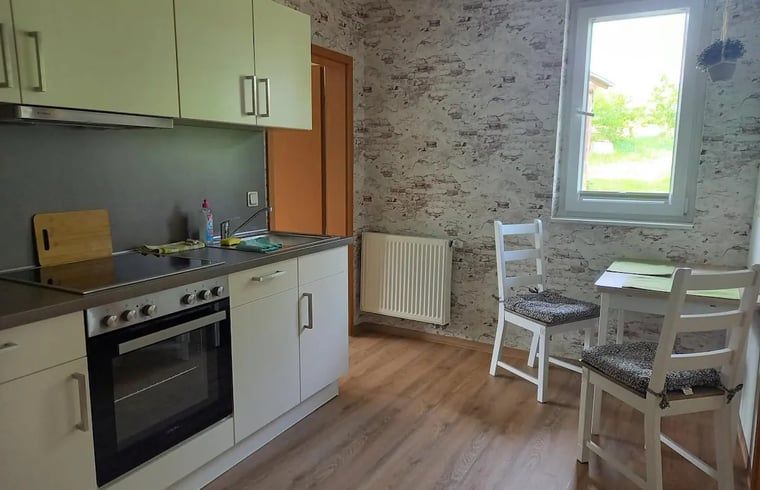 Moderne keuken in Vakantiehuis in Leinefelde-Worbis, Thuringen, Duitsland met eetruimte en uitzicht op de tuin.