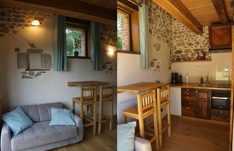 Gezellige binnenruimte van Vakantiehuisje in Espinasse, Auvergne, met rustieke stenen muren en houten interieur.