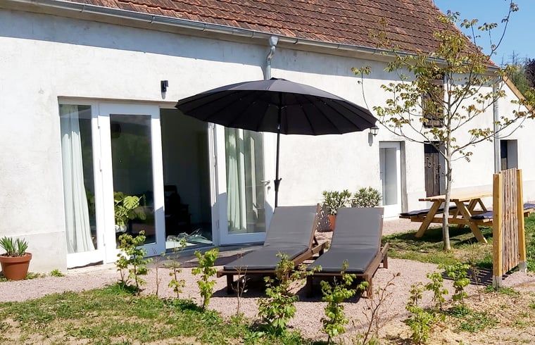 Geniet van de zon op het terras van Vakantiehuisje in Saint Bonnet Troncais, Auvergne, Frankrijk, met comfortabele ligstoelen.