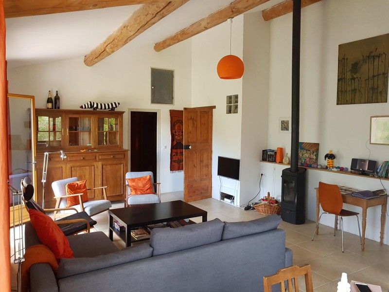 Gezellige woonkamer van Lodrem d'Angy vakantiehuis in Drome Provencale, Rhone-Alphes, met authentieke houten balken en moderne inrichting.