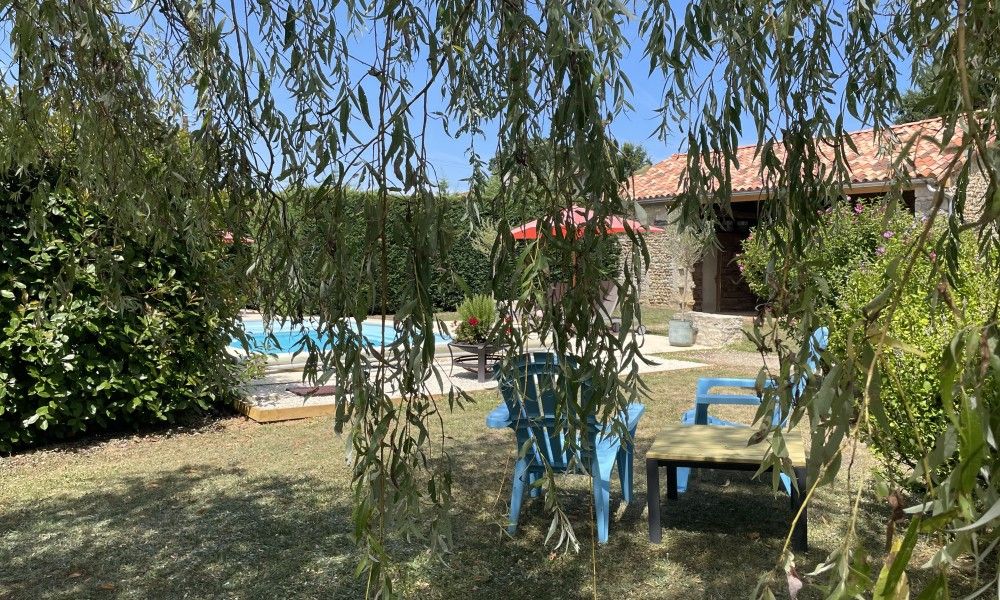Ontspan in de tuin van Le Reve de Breuillac, een charmant vakantiehuis in Civray, Poitou-Charentes, met zwembad en groene omgeving.