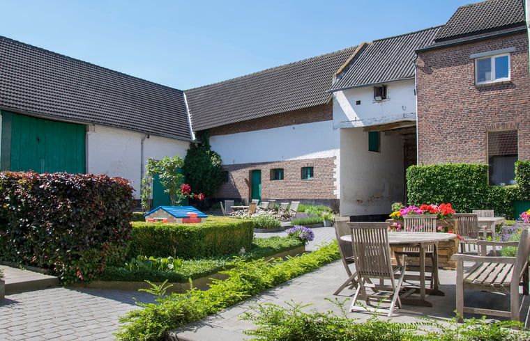 Gemuetliche Terrasse im Ferienhaus in Herderen, Limburg, Belgien mit Garten und Sitzbereich zum Entspannen in der Sonne.
