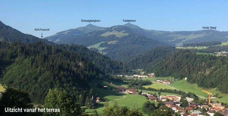 Adembenemend uitzicht vanaf het terras van Appartement Mariandl in Hopfgarten im Brixental, Tirol, omringd door bergen.