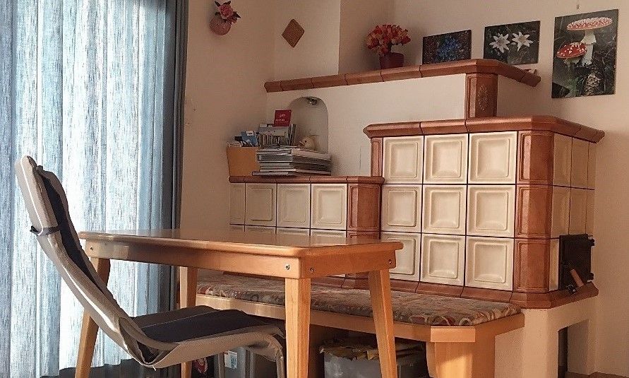 Gezellige binnenruimte van Appartement Mariandl in Hopfgarten im Brixental, Tirol, met een rustieke tegelkachel en houten meubilair.