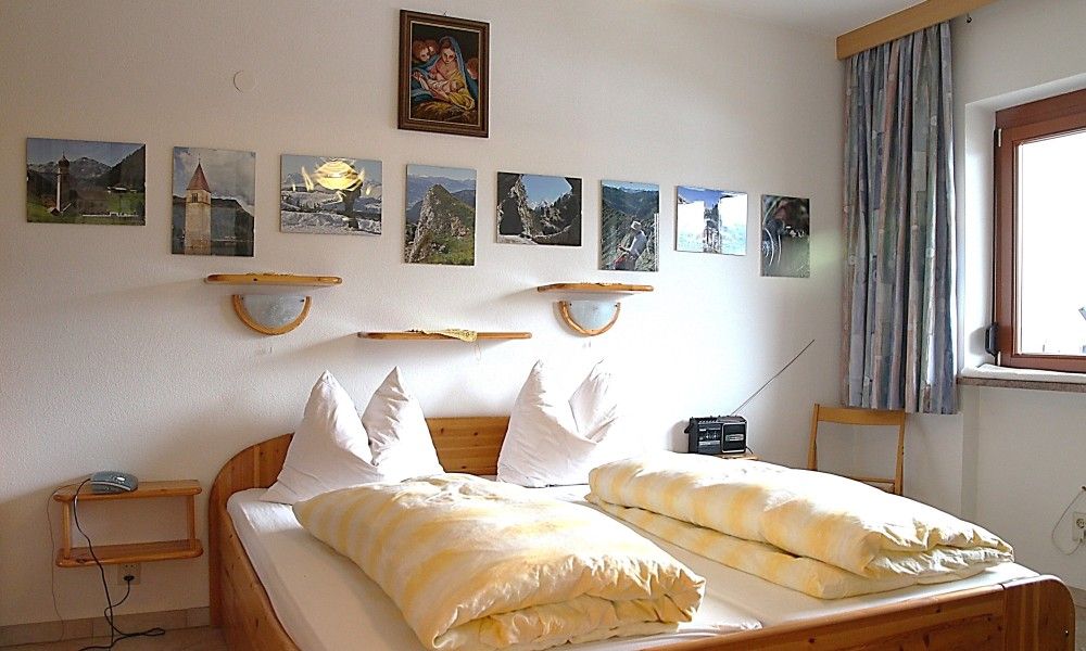 Gezellige slaapkamer in Appartement Mariandl, Hopfgarten im Brixental, Tirol, met comfortabele bedden en rustieke decoraties.