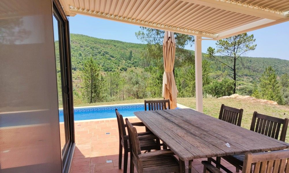 Geniet van het uitzicht op de groene heuvels vanaf het terras van Casa da Alfarobeira, een vakantiehuis in Sao Bartolomeu de Messines, Algarve.