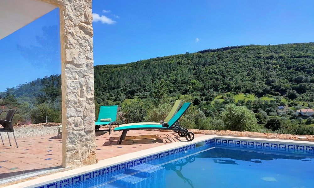 Geniet van het uitzicht op de groene heuvels vanuit Casa Bananeira villa 4P + baby met privezwembad in Sao Bartolomeu de Messines, Algarve.