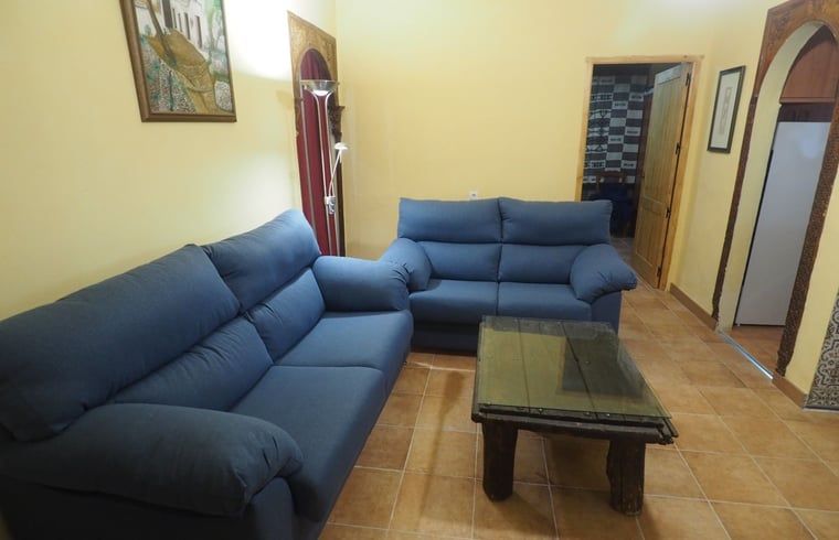 Gezellige woonkamer in Vakantiehuisje in La Taha, Pitres, Andalusie met comfortabele banken en rustieke details.