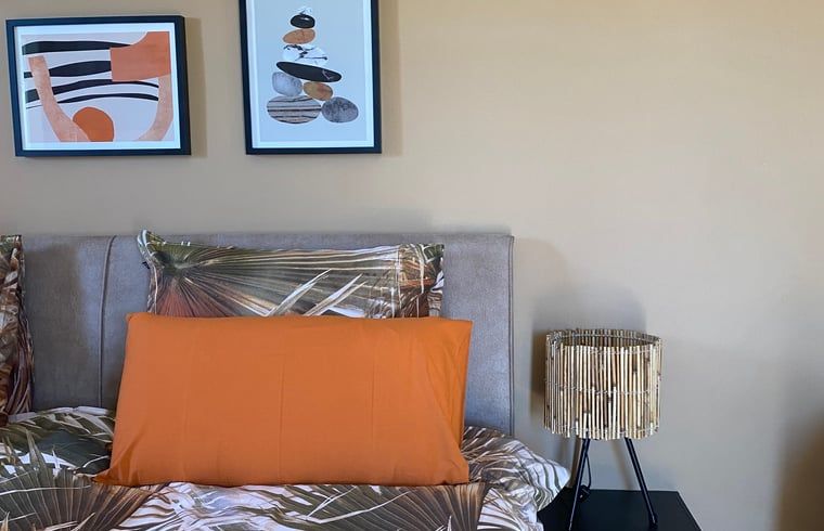 Gezellige slaapkamer in Vakantiehuis in Sedella, Andalusie met kunst en moderne inrichting voor een ontspannen verblijf.