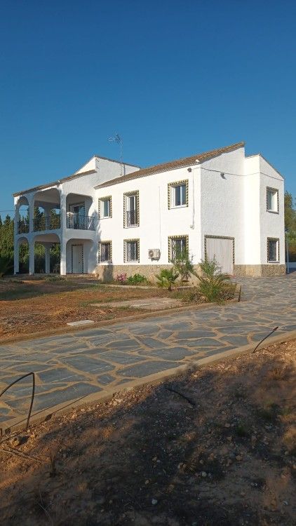 Finca Kim vakantiehuis in Lliria, Valencia, bij nacht verlicht met een uitnodigende veranda en omgeven door natuur.