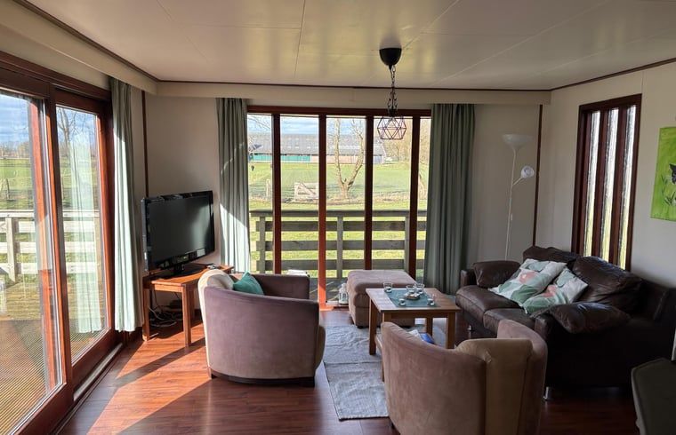 Geraeumiges Wohnzimmer im Ferienhaus in Wezuperbrug mit viel natuerlichem Licht in Midden Drenthe, Drenthe.