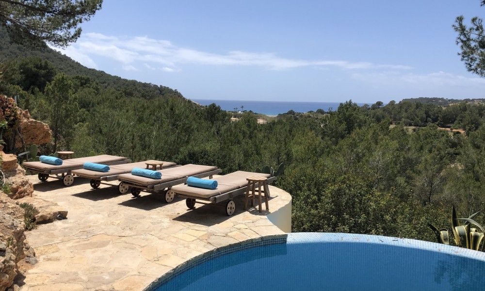Geniet van het adembenemende zeezicht vanaf het terras van La Luna Azul vakantiehuis in Cala Jondal, Ibiza, omgeven door weelderige natuur.