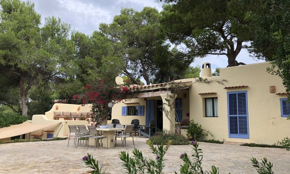 La Luna Azul vakantiehuis in Cala Jondal, Ibiza met ruime veranda omringd door weelderige natuur.