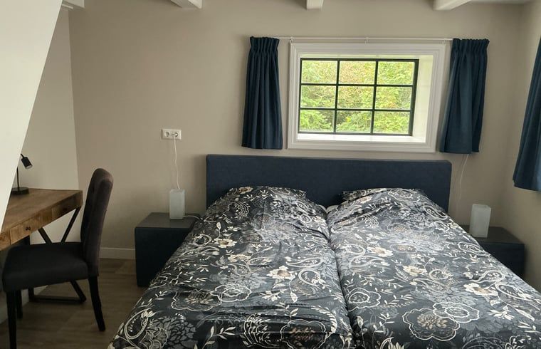 Ruime slaapkamer in Vakantiehuis in Nijemirdum, omgeven door de rust van Friesland.