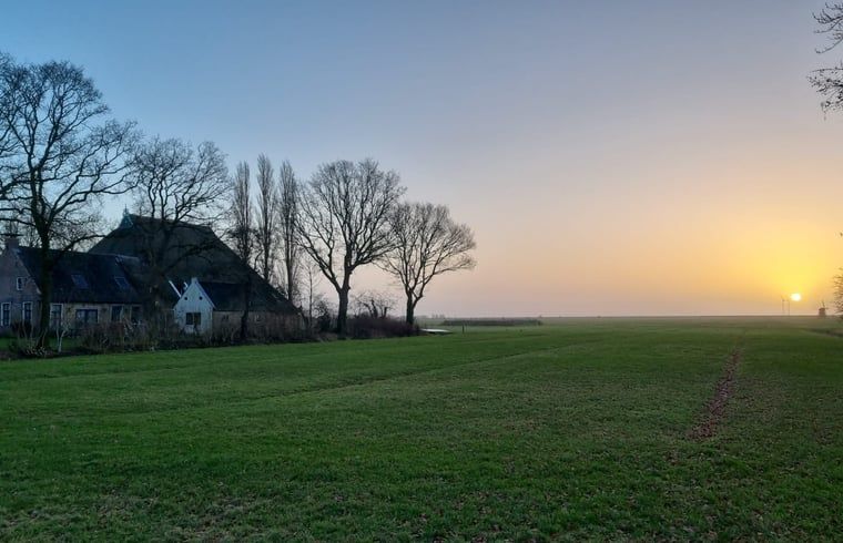 Adembenemende zonsondergang bij Vakantiehuis in Nijemirdum, met uitzicht op Friese velden.