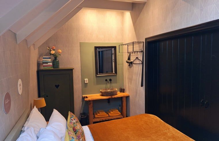 Sfeervolle slaapkamer in vakantiehuis Ternaard met rustieke details, Friesland.