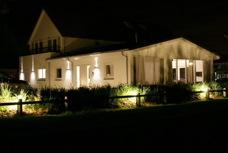 La Cabane vakantiehuis in Nieuwvliet-Bad sfeervol verlicht in de avond, omgeven door groene natuur.