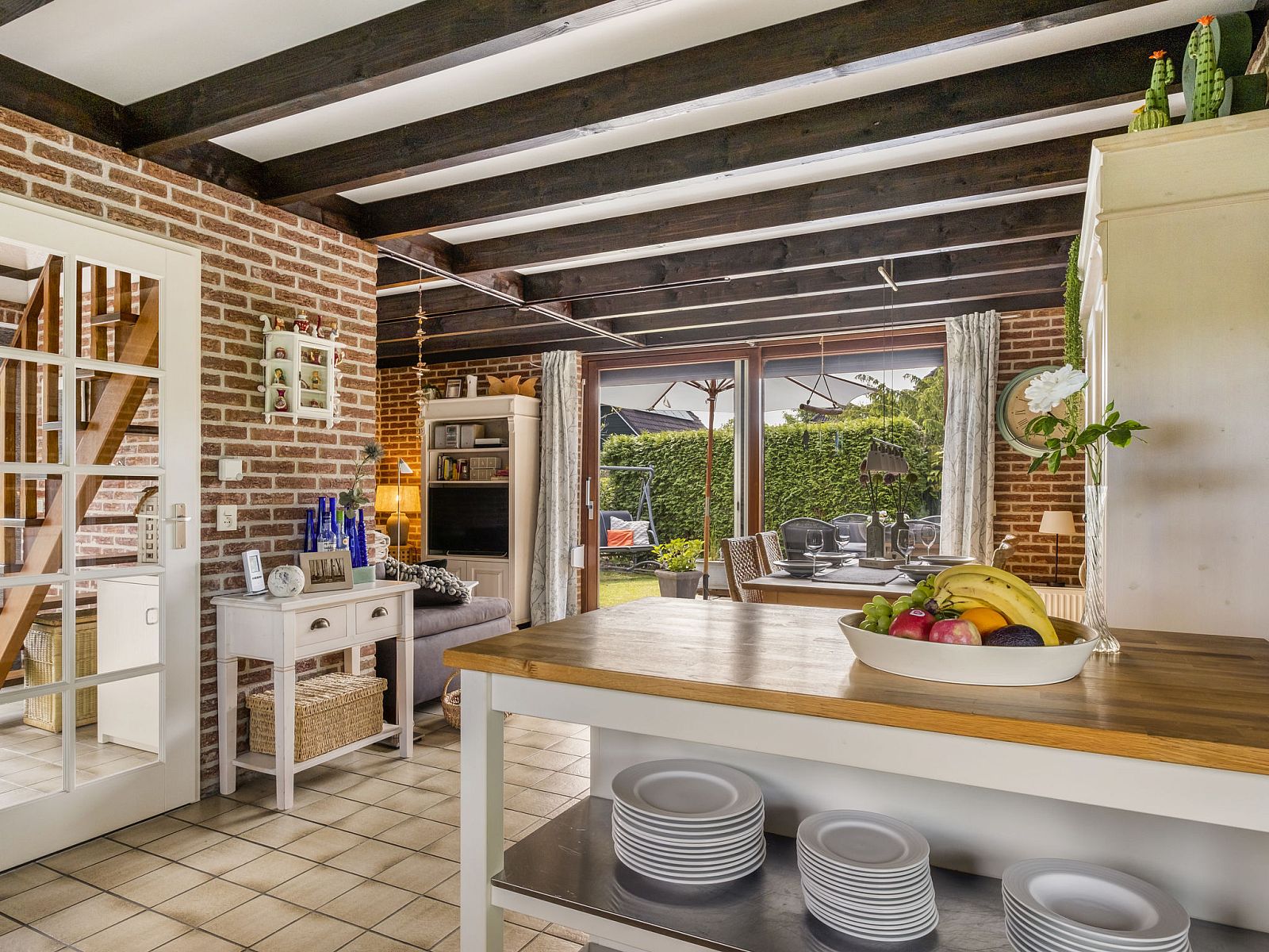 Lichte woonkamer van Vakantiehuis Haus Anni in Hansweert, Zuid-Beveland, met open keuken en uitzicht op de tuin.