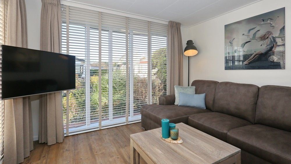 Gezellige woonkamer in De Duinpan 21 chalet met comfortabele bank in Noordwijk aan zee, Noordzeekust, Zuid-Holland.