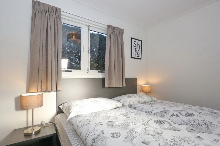 Knusse slaapkamer met tweepersoonsbed in De Duinpan 21 chalet, Noordwijk aan zee, Noordzeekust, Zuid-Holland.