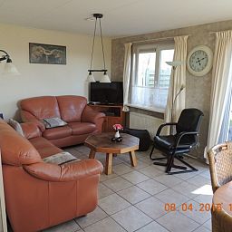 Ruime woonkamer in Bungalow 't Vinkie 4* in De Koog, Texel, met comfortabele zithoek en veel natuurlijk licht.
