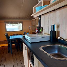 Gezellige keuken in Safaritent + sanitair, glamping lodge in Utscheid, Rijnland-Palts, Duitsland met eetruimte en houten interieur.