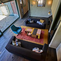 Stijlvolle woonkamer van vakantiehuis Lactea in Schilde, Antwerpen met moderne meubels en een ruimtelijk uitzicht op de tuin.