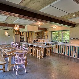 Stijlvolle keuken in vakantiehuis Lactea, Schilde, Antwerpen met houten interieur en grote ramen met uitzicht op de natuur.