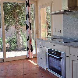 Moderne keuken in Villa Mouillieres, een vakantiehuis in Allemagne-en-Provence, met uitzicht op de groene omgeving van de Provence.
