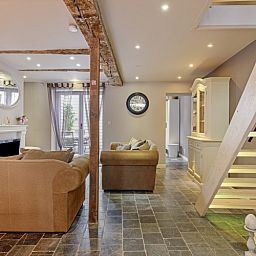 Innenbereich von Bibi Tongeren in Limburg, Belgien, mit einem stilvollen Kamin und einem grosszuegigen Sitzbereich zum Entspannen.