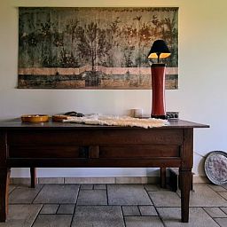 Stijlvolle eetkamer met kunstwerk in La Terre Ferme vakantiehuis, Houffalize, Ardennen, Belgie.