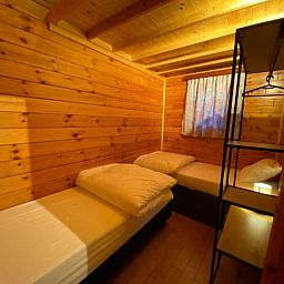 Gezellige slaapruimte in Chalet 't Musje, Weris, Ardennen met houten interieur.