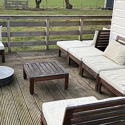 Gemuetliche Terrasse des Ferienhauses in Wezuperbrug mit komfortablen Sitzgelegenheiten in Midden Drenthe, Drenthe.