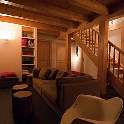 Gezellige woonkamer van Chalet Belpiano in Nendaz, Wallis, met houten balken en comfortabele zithoek.