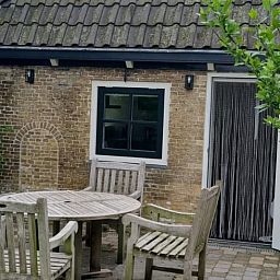 Gezellig terras bij Vakantiehuis in Nijemirdum, omgeven door de Friese natuur.