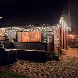 Romantisch verlichte buitenruimte van vakantiehuis in Ternaard, Friesland.