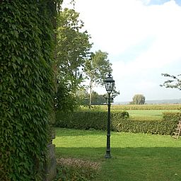 Groene tuin met lantaarn bij Vakantiehuis in De Steeg, Veluwe, Gelderland.