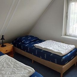 Slaapkamer met twee eenpersoonsbedden in Villa Zeerob, Scharendijke, perfect voor een ontspannen verblijf in Zeeland.