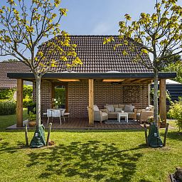 Ruim terras met zitgedeelte bij Vakantiehuis Haus Anni in Hansweert, Zuid-Beveland, omgeven door groen.