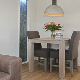 Eethoek met bloemen in De Duinpan 21 chalet, Noordwijk aan zee, Noordzeekust, Zuid-Holland, ideaal voor gezellige maaltijden.