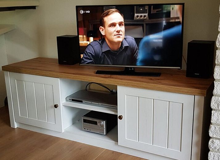 Terras van Ferienperle vakantiehuis in De Cocksdorp, Texel, omgeven door groen.