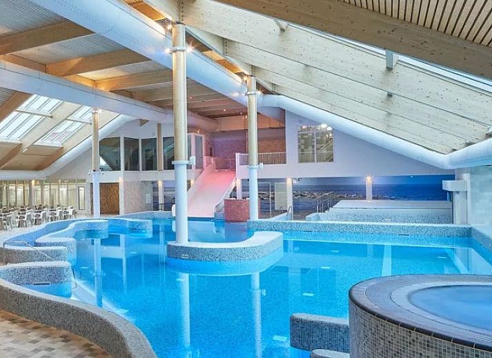 Zijaanzicht van Ferienperle vakantiehuis in De Cocksdorp, Texel, met bloeiende natuur.