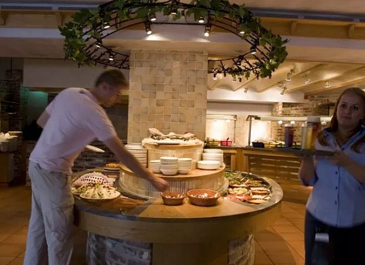 Zijaanzicht van Ferienperle vakantiehuis in De Cocksdorp, Texel, met bloeiende natuur.