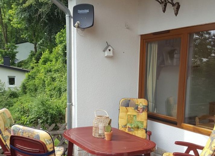 Genieten van een ontbijt op het terras van Vakantiehuisje Feriendorf B-18 in Husen, omgeven door de serene natuur van Noordrijn-Westfalen.