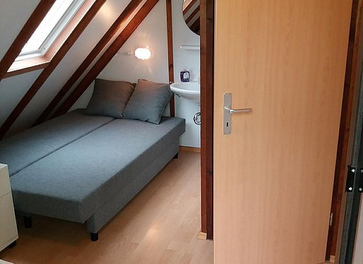 Gezellige woonkamer van Ekkie's Ecke vakantiehuis in Frankenau, Hessen, Duitsland, met houten interieur en comfortabele zithoek.